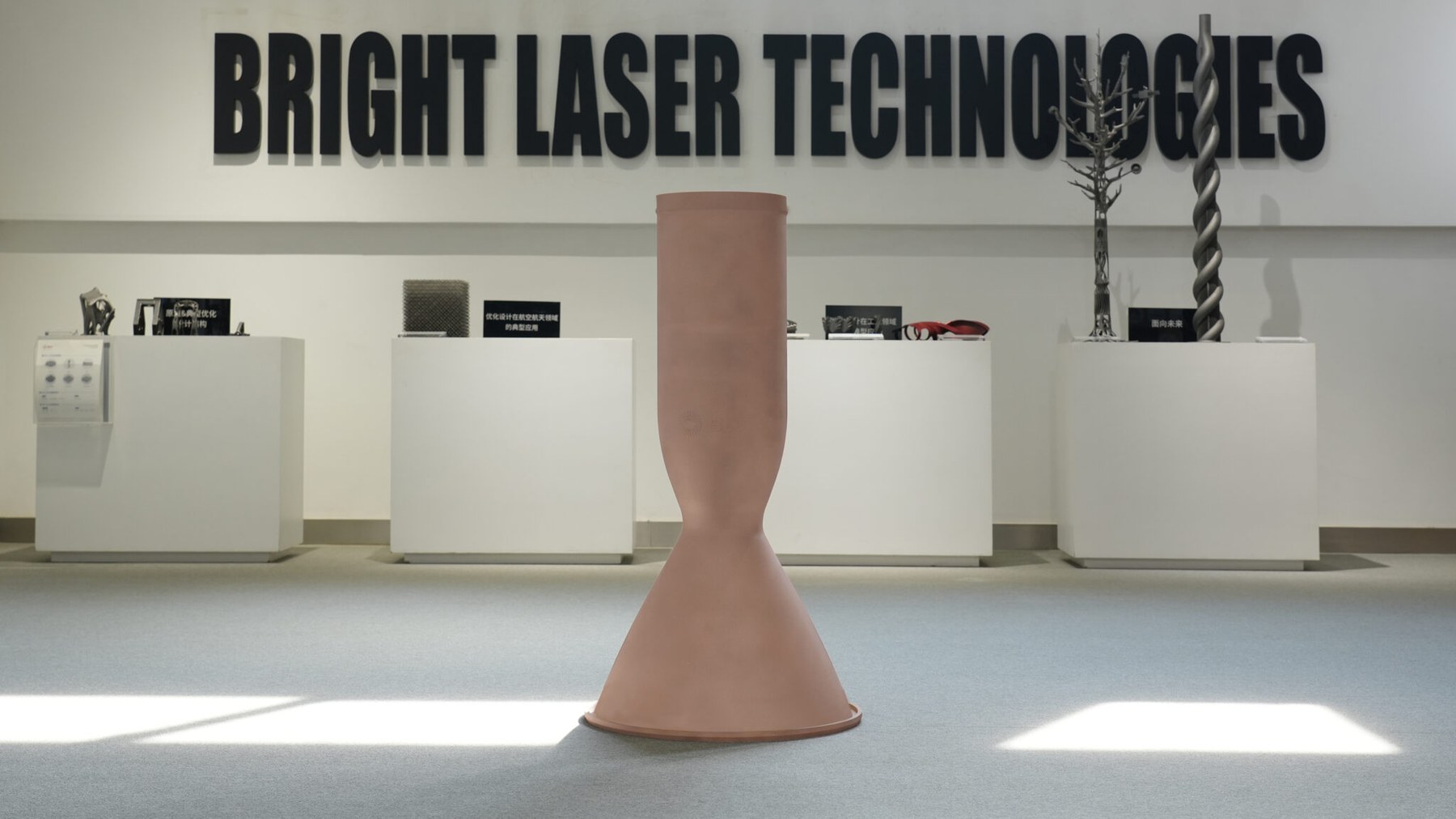 Large copper additive thrust-chamber liner blank standing in a showroom