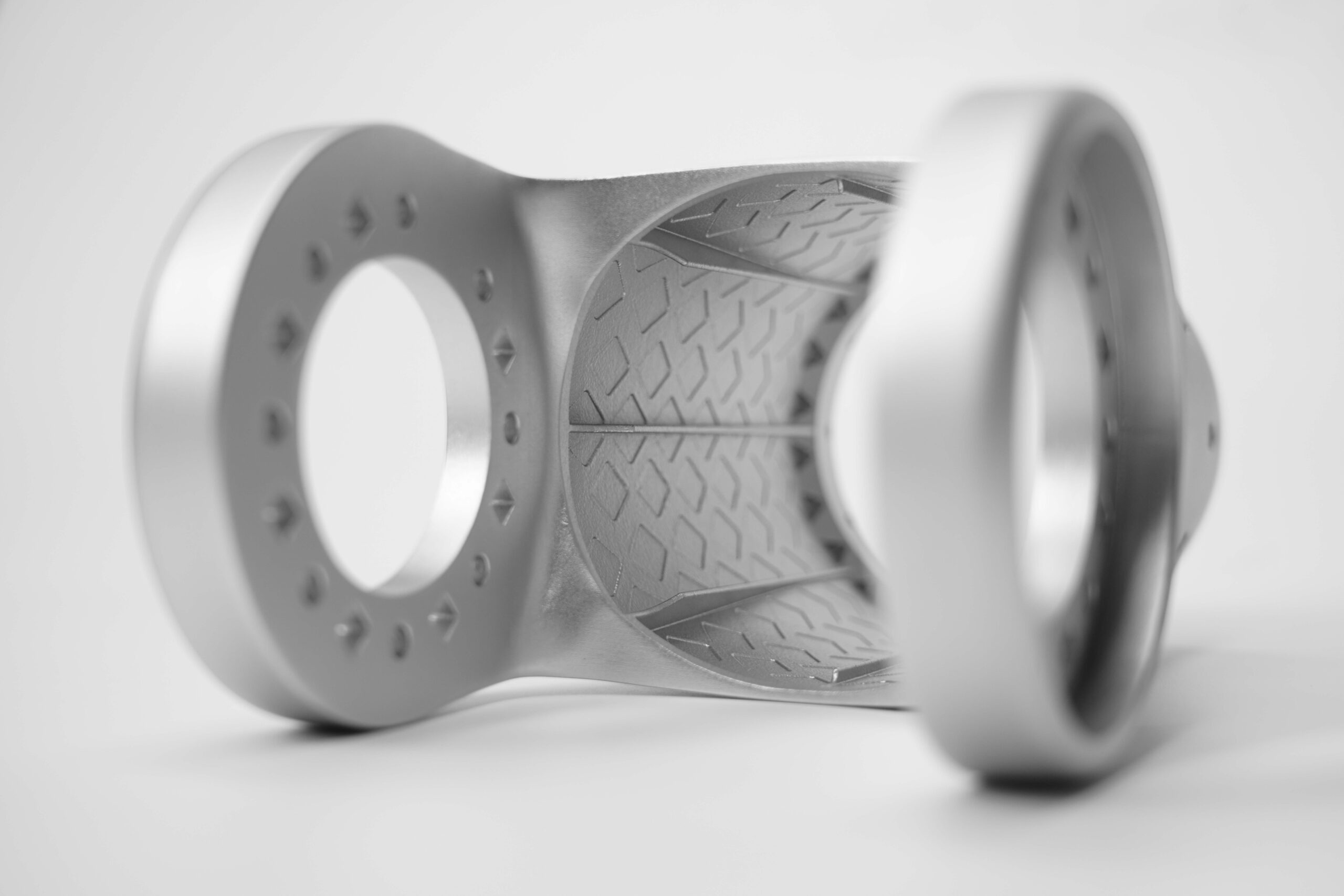 Close-up of metal AM robot flange joint with raised diamond interior liner texture