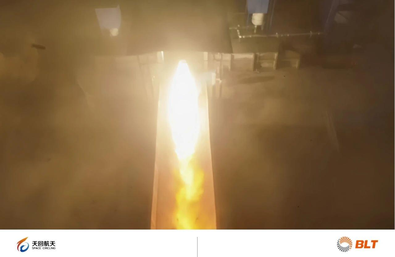 Top-down view of a propulsion hot-fire trench test with bright exhaust plume